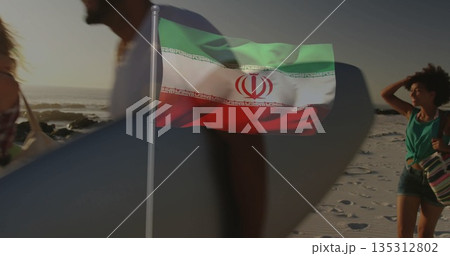 Waving metal flagpole hoisting tricolor banner at beach shoreline, with surfboard and striped tote Waving metal flagpole hoisting tricolor banner at beach shoreline, with surfboard and striped tote 135312802