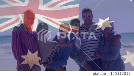 Smiling multigenerational family hugging each other on sandy beach by ocean, showing family bond 135312815