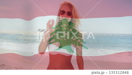 Woman adjusting hair on sandy beach, with sunglasses, white bikini top and striped cedar overlay Woman adjusting hair on sandy beach, with sunglasses, white bikini top and striped cedar overlay 135312848