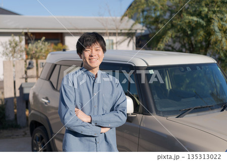 車の前で腕組みをする笑顔の男性 135313022
