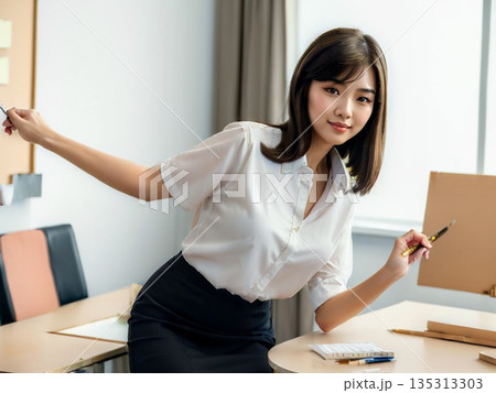 オフィス内のデスクで説明をする女性 135313303