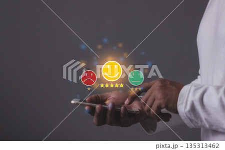 Consumer Satisfaction, Young Man hand holding Smart Phone with five star to review and give 5 stars with very good results in service, Good review 5 star rating choice feedback 135313462
