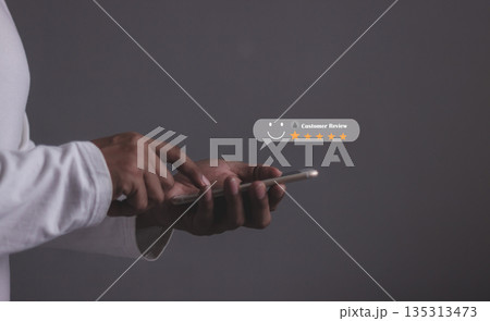 Consumer Satisfaction, Young Man hand holding Smart Phone with five star to review and give 5 stars with very good results in service, Good review 5 star rating choice feedback 135313473