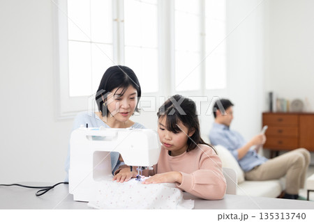 母親と一緒にミシンがけをする小学生の女の子 135313740