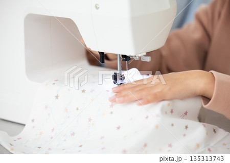 ミシンがけをする女の子の手元のクローズアップ 135313743