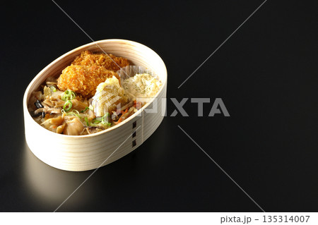 きのこご飯とカキフライ弁当を黒背景で撮影 135314007