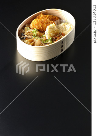 きのこご飯とカキフライ弁当を黒背景で撮影 135314013