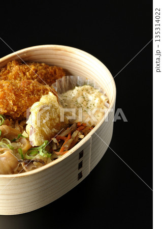 きのこご飯とカキフライ弁当を黒背景で撮影 きのこご飯とカキフライ弁当を黒背景で撮影 135314022