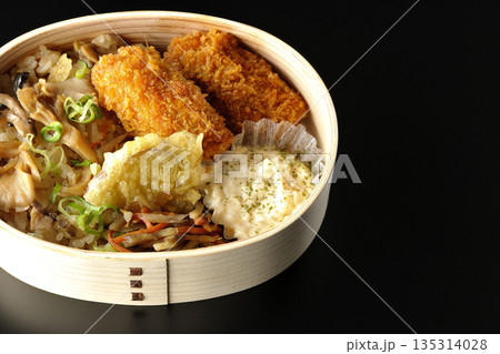 きのこご飯とカキフライ弁当を黒背景で撮影 きのこご飯とカキフライ弁当を黒背景で撮影 135314028