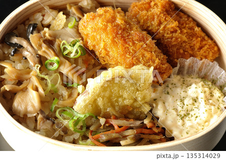 きのこご飯とカキフライ弁当を黒背景で撮影 きのこご飯とカキフライ弁当を黒背景で撮影 135314029