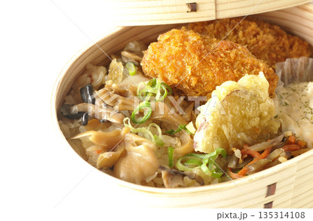 きのこご飯とカキフライ弁当を白背景で撮影 135314108