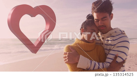 Hugging couple in mustard, striped sweater on beach at sunset, fading heart graphic, copy space Hugging couple in mustard, striped sweater on beach at sunset, fading heart graphic, copy space 135314525