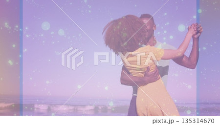 Dancing couple wearing yellow dress and short sleeved shirt spinning at beach shore, pastel filter Dancing couple wearing yellow dress and short sleeved shirt spinning at beach shore, pastel filter 135314670