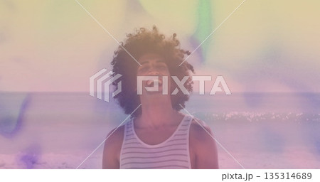 Laughing man wearing striped tank top standing at sandy beach, with pastel light leaks Laughing man wearing striped tank top standing at sandy beach, with pastel light leaks 135314689