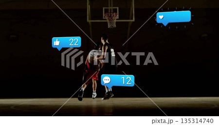 Dribbling basketball toward hoop, white dribbler facing defender on court with social media icons Dribbling basketball toward hoop, white dribbler facing defender on court with social media icons 135314740
