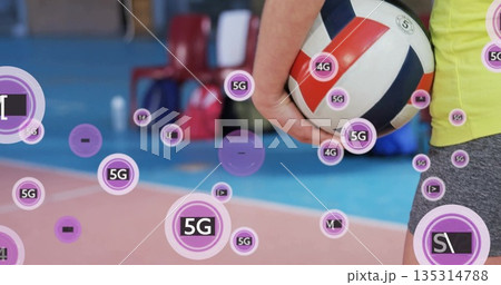 Girl wearing neon green sportswear holding red white blue volleyball at gym court edge, copy space Girl wearing neon green sportswear holding red white blue volleyball at gym court edge, copy space 135314788