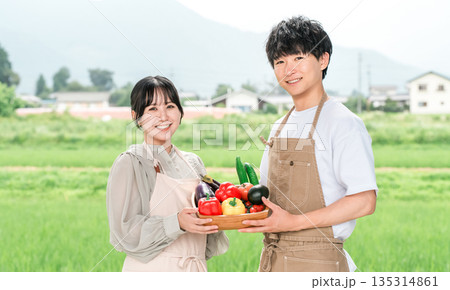 野菜を持つ農業従事者の男性と女性（農家,夏野菜,新鮮,ふるさと納税） 135314861