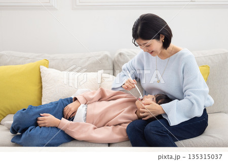 娘の歯を仕上げ磨きする母親 135315037
