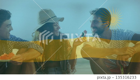 Eating watermelon slices, three friends wearing straw sunhat at seaside beach, summer picnic 135316233