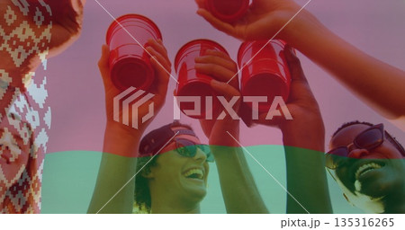 Raising group of friends wearing summer clothes and sunglasses outdoors, holding red cups in toast Raising group of friends wearing summer clothes and sunglasses outdoors, holding red cups in toast 135316265