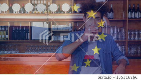 Leaning against wooden bar counter, man sipping beer from pint glass at taproom, with beer taps Leaning against wooden bar counter, man sipping beer from pint glass at taproom, with beer taps 135316266