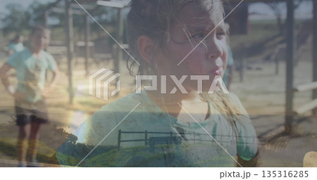 Girl catching breath in green tee at playground with metal frame bars, woodchip ground, copy space 135316285