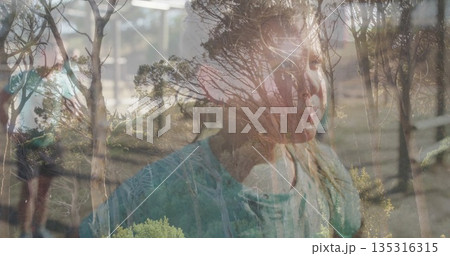 Blending longhaired girl's face with bare tree reflections on glass pane in room, with metal bars Blending longhaired girl's face with bare tree reflections on glass pane in room, with metal bars 135316315