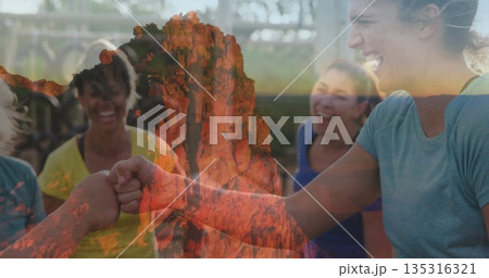 Cheering team members wearing sportswear sharing fist bump at gym with bars, red cliff overlay 135316321