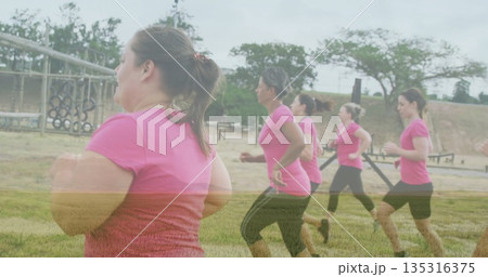 Jogging woman in pink workout clothes at exercise park with monkey bars, hanging tires, copy space 135316375