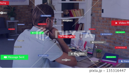 Man wearing shirt looking at laptop screen with child in home office with notifications, copy space 135316447