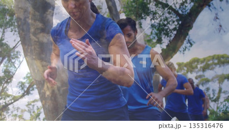 Running woman in blue shirt leaning along tree-lined grassy trail, with training group, copy space Running woman in blue shirt leaning along tree-lined grassy trail, with training group, copy space 135316476