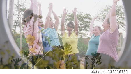 Cheering six women in activewear raising arms on wooden obstacle platform, with ropes and trees Cheering six women in activewear raising arms on wooden obstacle platform, with ropes and trees 135316583