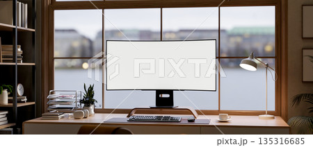 Blank curved screen computer and coffee cup on wooden table in a glass wall living room or office. Blank curved screen computer and coffee cup on wooden table in a glass wall living room or office. 135316685