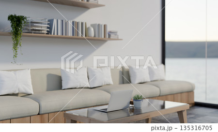 Laptop and coffee cup on glass top wooden table aside fabric sofa set in living room or cafe lounge. Laptop and coffee cup on glass top wooden table aside fabric sofa set in living room or cafe lounge. 135316705
