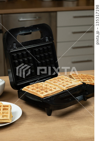 Freshly Baked Golden Waffles Inside an Open Electric Waffle Maker. Freshly Baked Golden Waffles Inside an Open Electric Waffle Maker. 135317198
