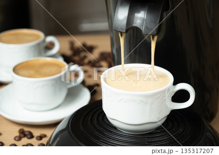 Process of making coffee using a pod machine with two streams of beverage. 135317207