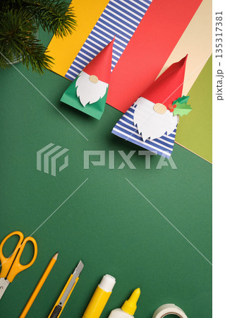 Handcraft gnomes with colorful paper and art supplies on green background. Handmade creativity. Copyspace Handcraft gnomes with colorful paper and art supplies on green background. Handmade creativity. Copyspace 135317381