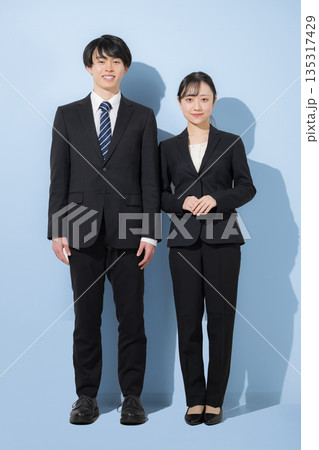 水色背景の若いビジネスマンの大学生のような男女　新卒採用や就職など信頼感を伝える企業採用イメージ　カ 135317429