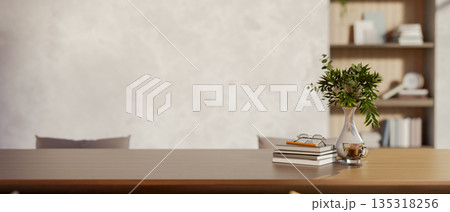 Glasses and pencil atop books aside vase on wooden table in a room with loft wall and build in shelf Glasses and pencil atop books aside vase on wooden table in a room with loft wall and build in shelf 135318256