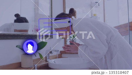 Leaning robe-clad woman cupping water under faucet at bathroom sink with orchid, copy space Leaning robe-clad woman cupping water under faucet at bathroom sink with orchid, copy space 135318407