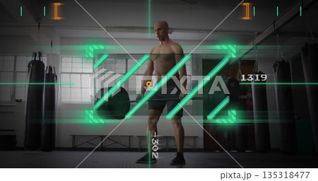Holding loaded barbell shirtless man preparing deadlift in gym, with punching bags and AR overlay 135318477