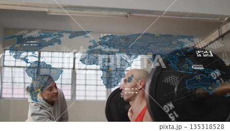 Spotting trainer assisting man in red tank top performing barbell squat in gym with digital overlay 135318528