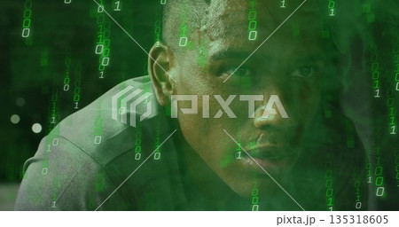 Analyzing code man wearing grey shirt leaning forward in digital scene, with flowing binary digits 135318605