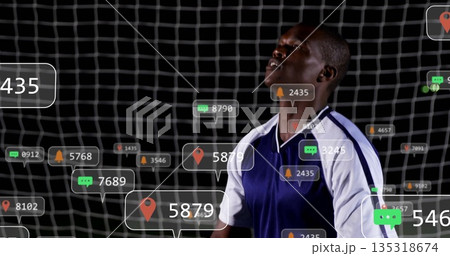 Standing player wearing blue white jersey in front of goal net, floating digital icons, copy space Standing player wearing blue white jersey in front of goal net, floating digital icons, copy space 135318674