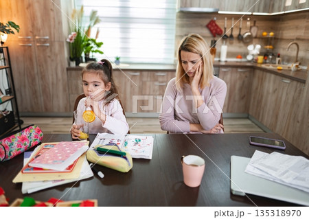 Child enjoying juice while mother reflects on challenges at home Child enjoying juice while mother reflects on challenges at home 135318970