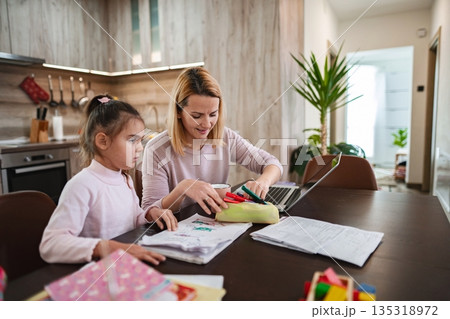 Creative moments shared between mother and daughter at home learning activities 135318972