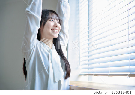 伸びをする20代女性のビューティーポートレート 135319401