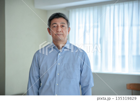 カメラ目線で立つ笑顔の60代の男性 カメラ目線で立つ笑顔の60代の男性 135319829
