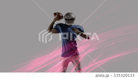 Holding football, preparing to pass in studio, quarterback wearing helmet with pink streak graphics 135320133
