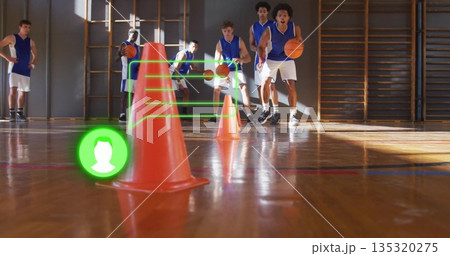 Dribbling basketballs, six men maneuvering around orange traffic cones in school gym, with gym bars Dribbling basketballs, six men maneuvering around orange traffic cones in school gym, with gym bars 135320275